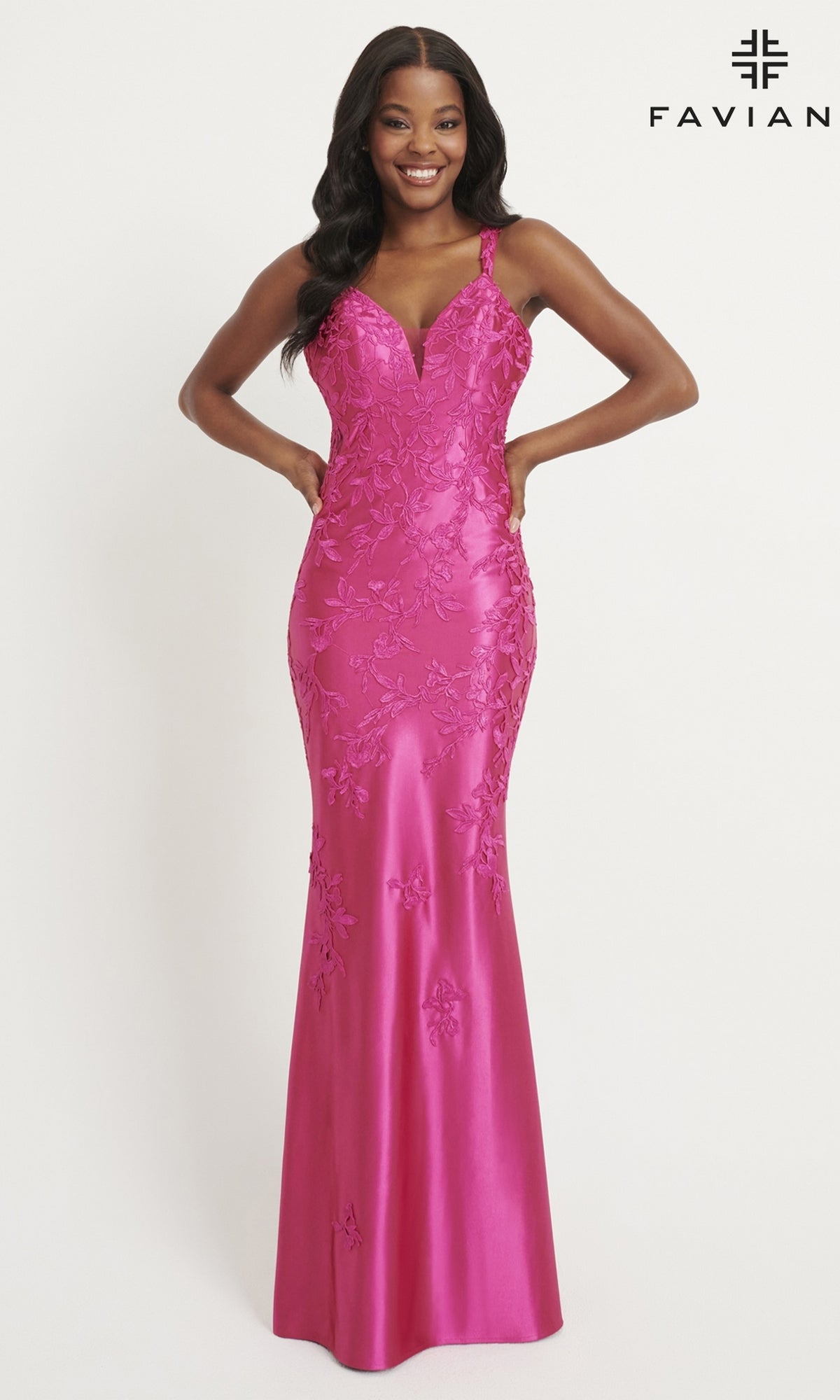 A woman models the Faviana Tonal-Lace Long Prom Dress 11082 in fitted fuchsia stretch satin with floral embroidery, deep V-neck, and wide straps. The elegant, floor-length gown is showcased against a plain white background.
