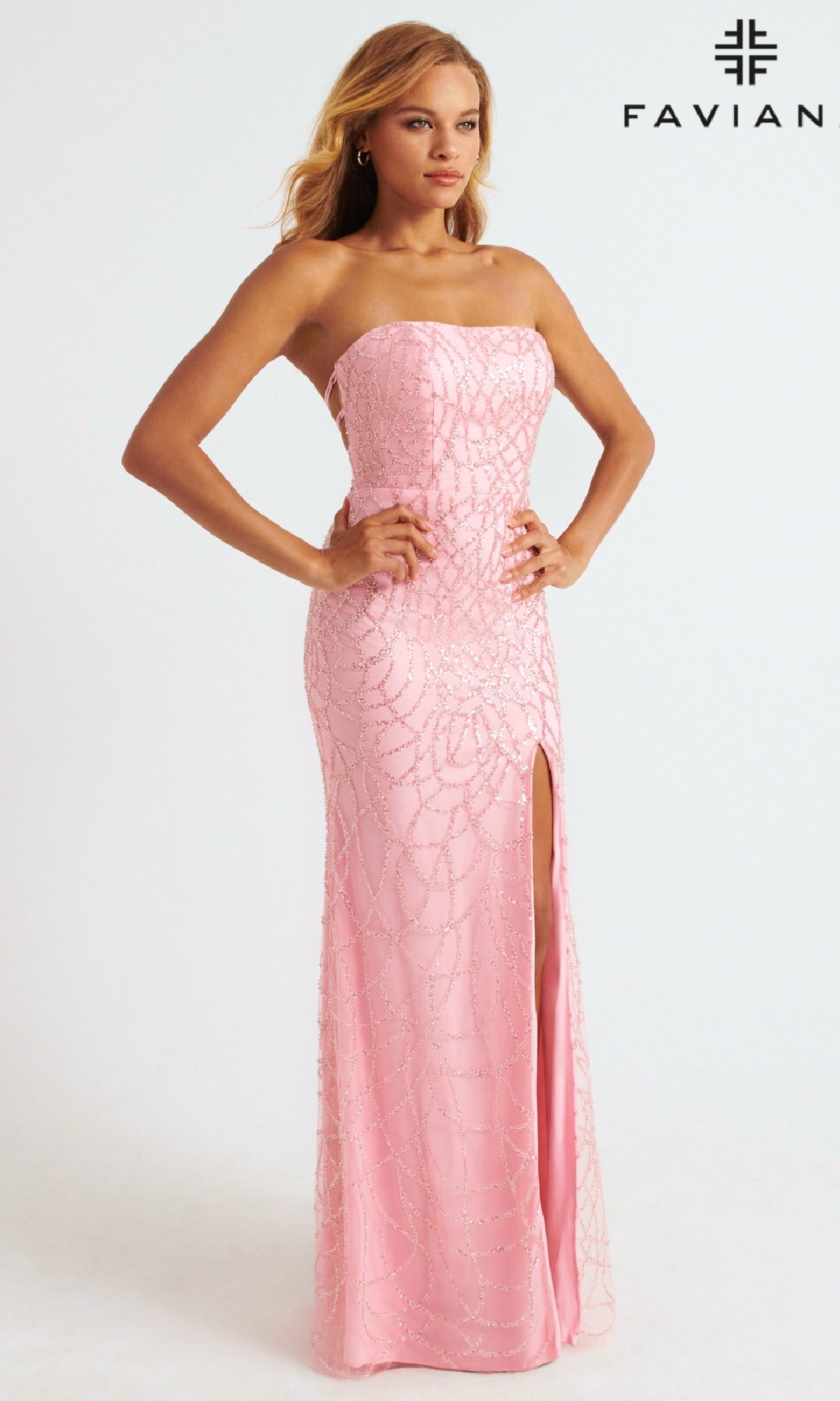 A woman poses in the Strapless Faviana Long Glitter-Print Prom Dress—a floor-length pink gown with bead details and a thigh-high slit. The 