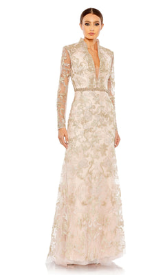 A woman stands against a plain white background wearing the Mac Duggal 11165 Long Sleeve Lace Formal Gown, a vintage-style floor-length dress with gold embroidery and a plunging neckline.
