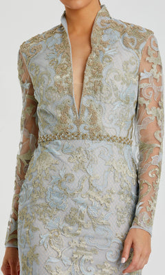 A woman wearing the Mac Duggal 11165 Long Sleeve Lace Formal Gown, featuring vintage style, sheer panels, and ornate gold embroidery over a pale blue base.