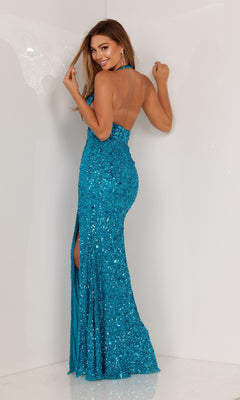 Model in the Embellished Long Halter Prom Dress 1116, a shimmering blue sequin gown with a halter neckline and high slit, stands against a plain light background, glancing over her shoulder.