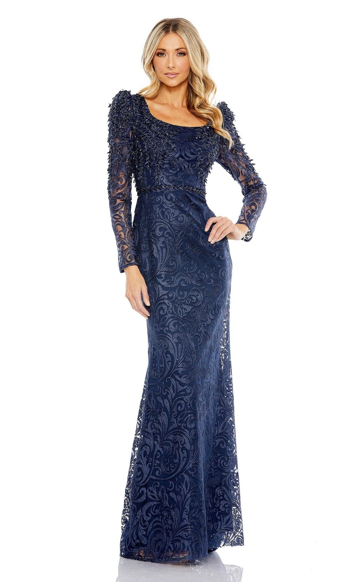 A woman stands against a white background wearing the Mac Duggal 11187 Long Sleeve Long Formal Gown—a navy blue evening dress with lace and intricate details, ideal as a mother of the bride outfit.