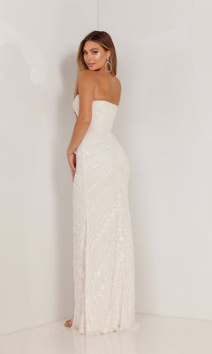 A woman stands facing away, wearing the Aleta Long Prom Dress 1118—a strapless, floor-length white gown with geometric sequin patterns.