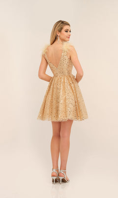 A woman faces away in the Dave and Johnny Short Gold Sequin Hoco Dress 11227, featuring a deep V-back and feathered shoulders, paired with silver heels, set against a plain light background.
