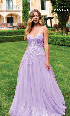 A woman in the Faviana 11230 Long Lace-Bodice A-Line Prom Dress poses outdoors by a manicured garden and grand building. "FAVIAN" is displayed in the top right corner.