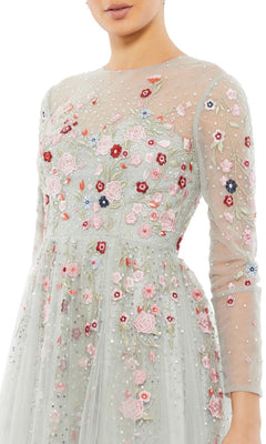 A woman wearing the Long Formal Dress 11241 by Mac Duggal, featuring sheer long sleeves and detailed pink, red, and white floral embroidery accented with pearls.