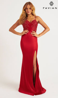 A woman wearing the Faviana 11256 long prom dress in red satin, featuring a fitted silhouette, thin straps, lace bodice detailing, and a high leg slit. The FAVIAN logo appears in the top right corner.