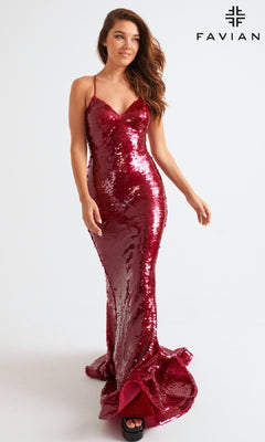 A woman wearing the Faviana 11261 long prom dress—fitted, floor-length, red with sequins, thin straps, and a v-neckline—stands against a plain white background. The FAVIAN logo is shown in the top right corner.