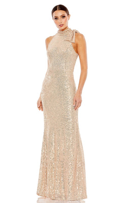 A woman stands against a white background wearing the Mac Duggal 11280 Bow Long Sequin Formal Dress—sleeveless, floor-length, gold sequins, high neckline, and bow detail on one shoulder.