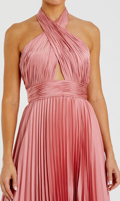 A person wearing the Long Formal Dress 11302 by Mac Duggal, a blush pink sleeveless gown with a pleated halter neck, crisscross bodice, and keyhole detail.