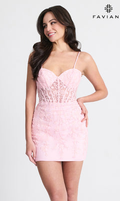 A woman models the Sheer-Bodice Short Lace Hoco Dress: Faviana 11304—featuring thin straps, a sheer bodice, and floral embroidery—while standing against a plain background with the "FAVIAN" logo in the top right corner.
