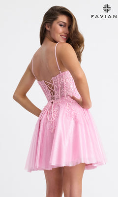 A woman smiles in the Faviana 11305 Short Fit-and-Flare Hoco Dress, featuring beaded floral appliqué, a light pink lace-up back, fitted bodice, and flared skirt.