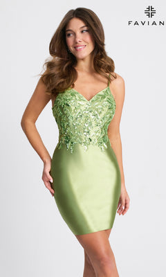 A woman models the Twist-Back Short Satin Hoco Dress (Faviana 11310) in light green with sequin-embellished bodice, posing against a plain background featuring the Faviana logo.