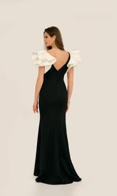 Woman in the Dave & Johnny 11314 Ruffle-Shoulder Prom Dress, featuring white ruffled shoulder details, standing and facing away against a plain light background.