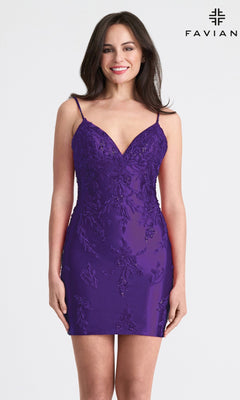 A woman stands and smiles in front of a plain background, wearing the Beaded Short Sheath Hoco Dress: Faviana 11315—a sleeveless, deep purple cocktail dress with floral embroidery. "FAVIAN" is visible in the top right corner.