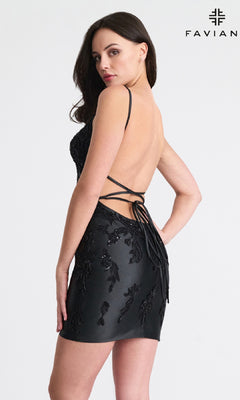 A woman poses with her back to the camera in the Beaded Short Sheath Hoco Dress: Faviana 11315, featuring a strappy back and black beading. The "FAVIAN" logo appears in the top right corner.