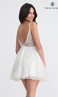 A woman poses against a plain background in the Faviana 11319, a short A-line sequin hoco dress in white with an elegant deep V back. The brand name "FAVIANA" appears in the top right corner.