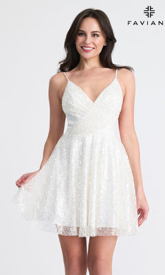 A woman smiles against a plain background, wearing the Faviana 11319 Short A-Line Sequin Hoco Dress with thin straps and a V-neck. "FAVIAN" appears in the top right corner.