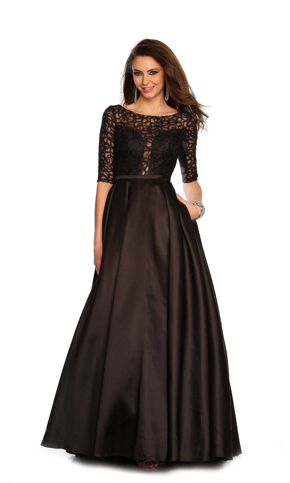 A woman stands and smiles against a white background in the Dave & Johnny 11345 Sleeved Long Prom Ball Gown, featuring a black lace bodice and half sleeves.
