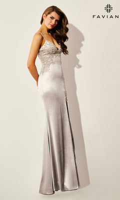 A woman models the Faviana 11401 long prom dress—silver satin with lace appliqué, thin straps, strappy open back, and a slight train. "FAVIAN" is seen in the top right corner against a plain background.