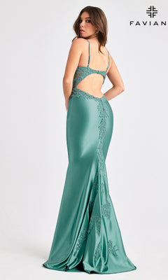A woman wearing the Faviana 11403, a floor-length sleeveless green prom dress with lace details and open back, stands looking over her shoulder. The Faviana logo appears in the top right corner.