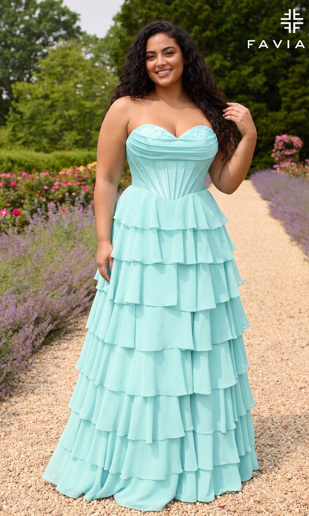 A plus-size woman wears a sea glass Faviana 11436E prom dress with a strapless corset bodice and a tiered ruffled chiffon skirt.