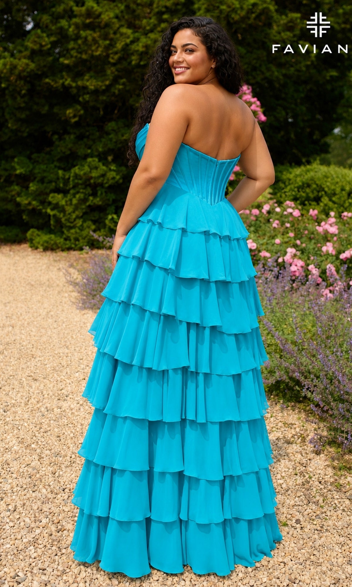A woman wearing the Long Plus-Size Prom Dress: Faviana 11436E, a bright blue, strapless ruffled chiffon dress with a corset-style bodice and a tiered, floor-length skirt.