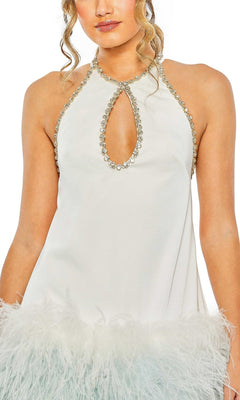 A woman wears the Mac Duggal Short Homecoming Dress 11437, a sleeveless white dress with feather trim, a jeweled halter neckline, and a keyhole cutout—perfect for making a statement at any event.