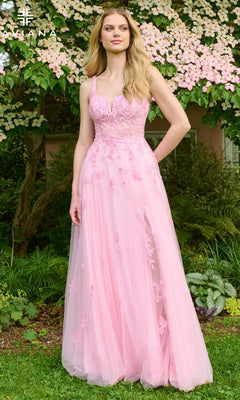 A woman stands outdoors in the Faviana 11437 long prom dress—a light pink, sleeveless, A-line gown with floral embroidery and a fitted bodice. Lush greenery and pink flowers in the background highlight her elegant tulle look.