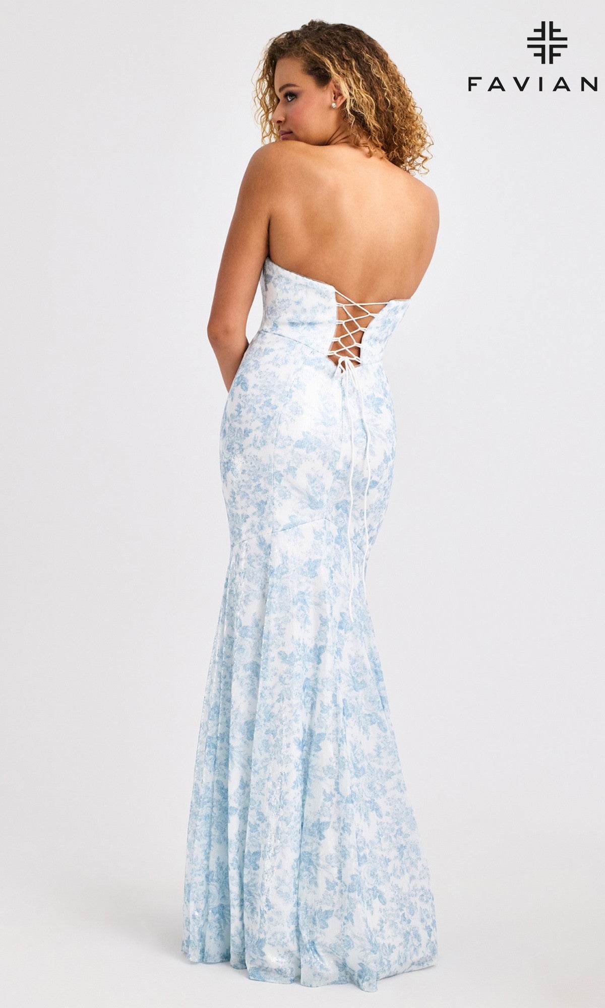 A woman models the Faviana 11441 Long Prom Dress—a light blue floral sequin mermaid gown with a strapless lace-up back—standing before a plain white backdrop featuring the FAVIAN logo in the top right corner.