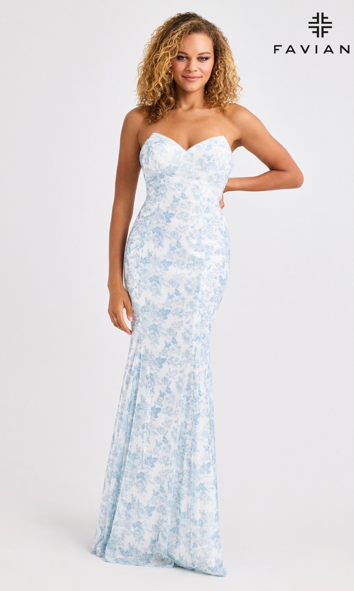 A woman poses against a plain background in the Faviana 11441 long prom dress, featuring a strapless, form-fitting mermaid silhouette with a light blue floral print. The FAVIAN logo appears in the top right corner.