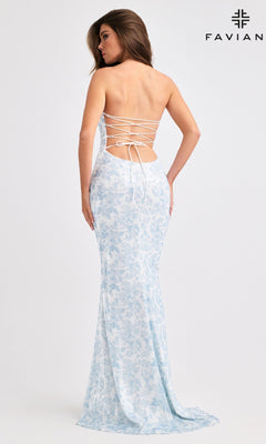 A woman wearing Faviana 11442, a floor-length, backless light blue and white floral prom dress with lace-up detail, stands against a plain background.