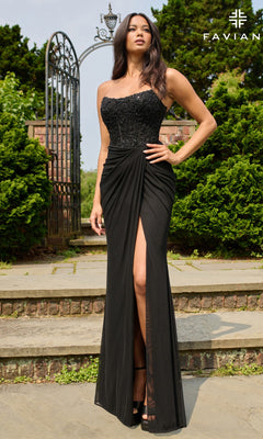 A woman poses gracefully outdoors before a gated garden entrance, wearing the Faviana 11445 long prom dress with a strapless beaded corset bodice and a thigh-high slit.