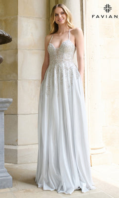 A woman wearing the Faviana 11449 long prom dress, a silver embellished A-line gown with thin straps and a fitted beaded bodice, stands before a stone wall.