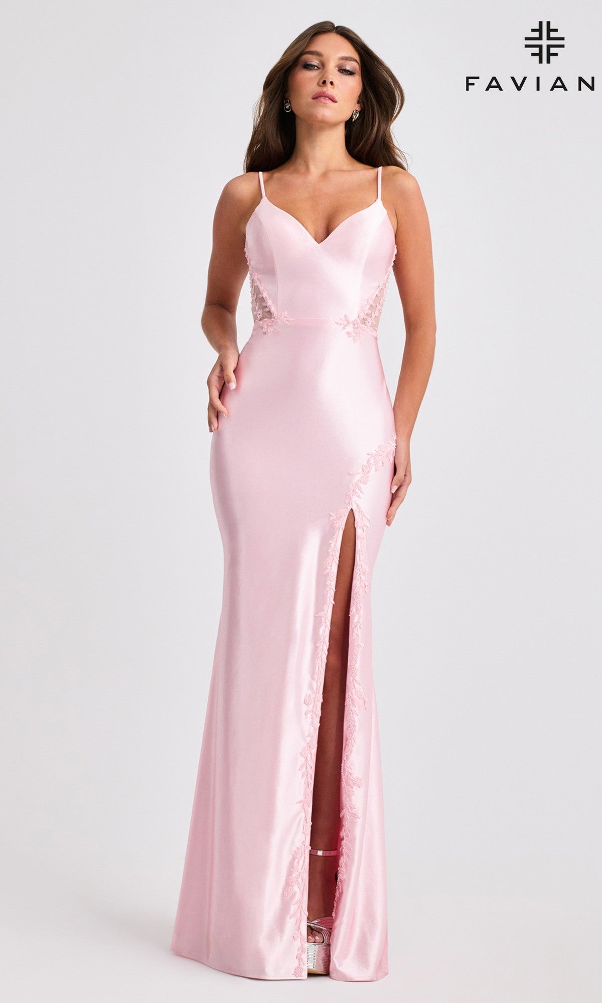 A woman wears the Faviana 11466 long prom dress—a fitted light pink satin gown with thin straps, lace side panels, and a thigh-high front slit. The 