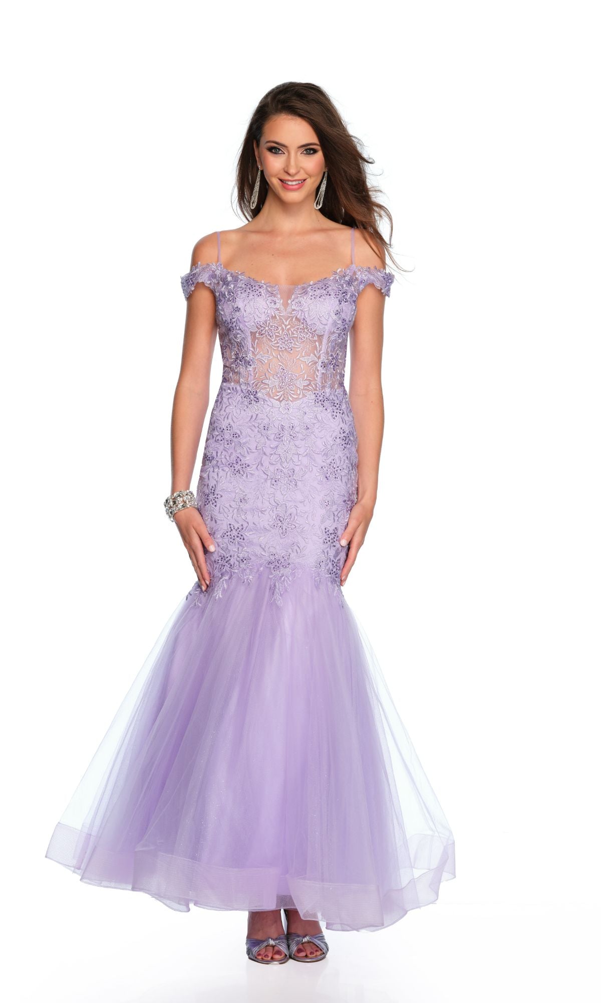 A woman wearing the Long Formal Dress 11505 by Dave and Johnny—an off-the-shoulder, pastel lilac mermaid gown with lace detailing and sheer panels—stands against a white background.