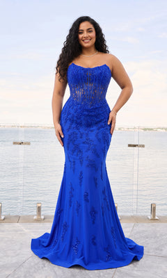 A person wears a royal blue, strapless, floor-length Faviana 11600E corset gown with a beaded bodice and a mermaid-style skirt.