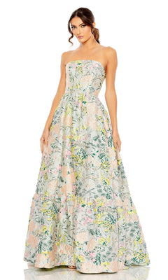 A woman wears the Strapless Brocade Formal Gown: Mac Duggal 11604, a floor-length, strapless dress with a full skirt and nature-inspired pastel floral print.
