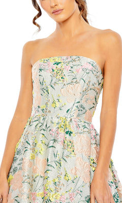 Woman modeling the Strapless Brocade Formal Gown: Mac Duggal 11604, featuring a floral pastel design, with the upper body and part of her arm visible.