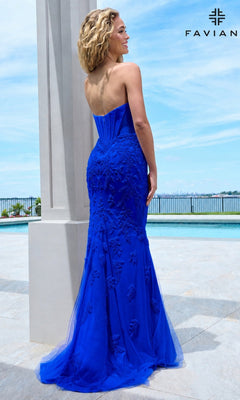 A person wearing a royal blue Faviana 11604 strapless corset prom dress with an embroidered skirt, standing on a patio by a pool.