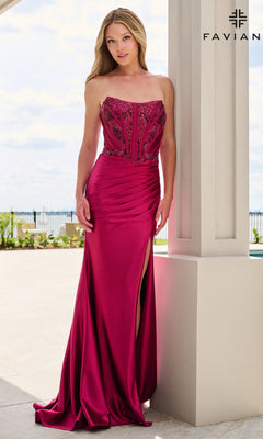 A woman wears a cherry-colored, floor-length satin Faviana 11606 prom dress with a strapless corset bodice and a high side slit.