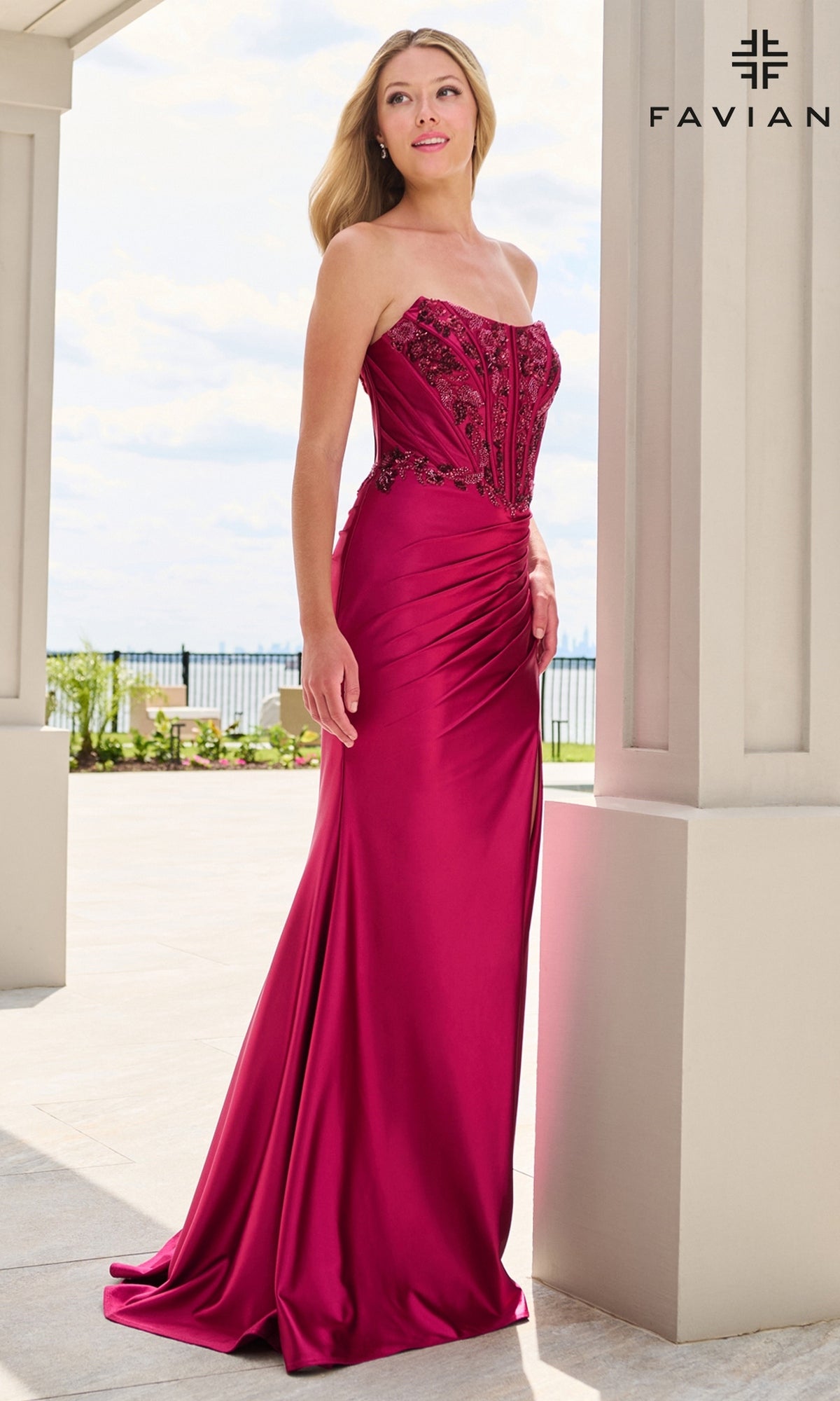 A woman wearing a floor-length magenta Faviana 11606 prom dress with a strapless, beaded corset bodice.
