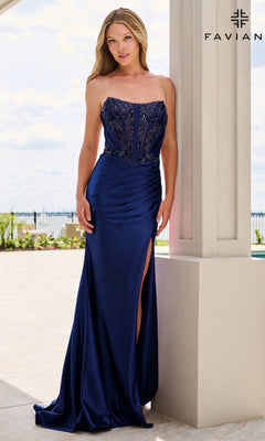 A woman wears a navy Faviana 11606 long prom dress, a strapless floor-length gown featuring a beaded corset bodice and a side leg slit.