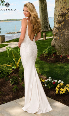 A woman wearing a Faviana 11611 floor-length, backless V-neck prom dress embellished with pearls.
