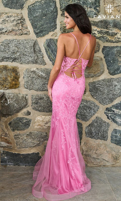 A woman wearing the pink lace Faviana 11624 long prom dress, featuring a mermaid silhouette, spaghetti straps, and a corset-style lace-up back.