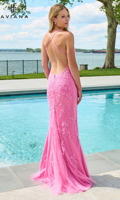 A woman stands by a pool wearing a Faviana 11626 floor-length pink tulle prom dress with a backless design and beaded lace appliques.