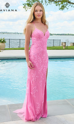 A woman wearing a cotton candy pink Faviana 11626 tulle prom dress with a V-neckline, spaghetti straps, and floral embroidery standing beside a swimming pool.