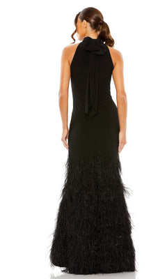A woman stands with her back to the camera, wearing the Mac Duggal 11627 long black feather formal dress featuring a sleeveless design, bow at the neck, and feathered skirt detailing.