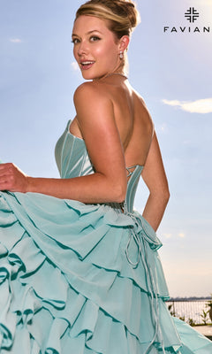 Woman wearing a light blue Faviana 11631 prom dress with a satin corset bodice, a strapless neckline, and a ruffled skirt.