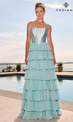 A woman wearing a light blue Faviana 11631 strapless tiered floor-length gown with a satin corset bodice standing by a swimming pool.